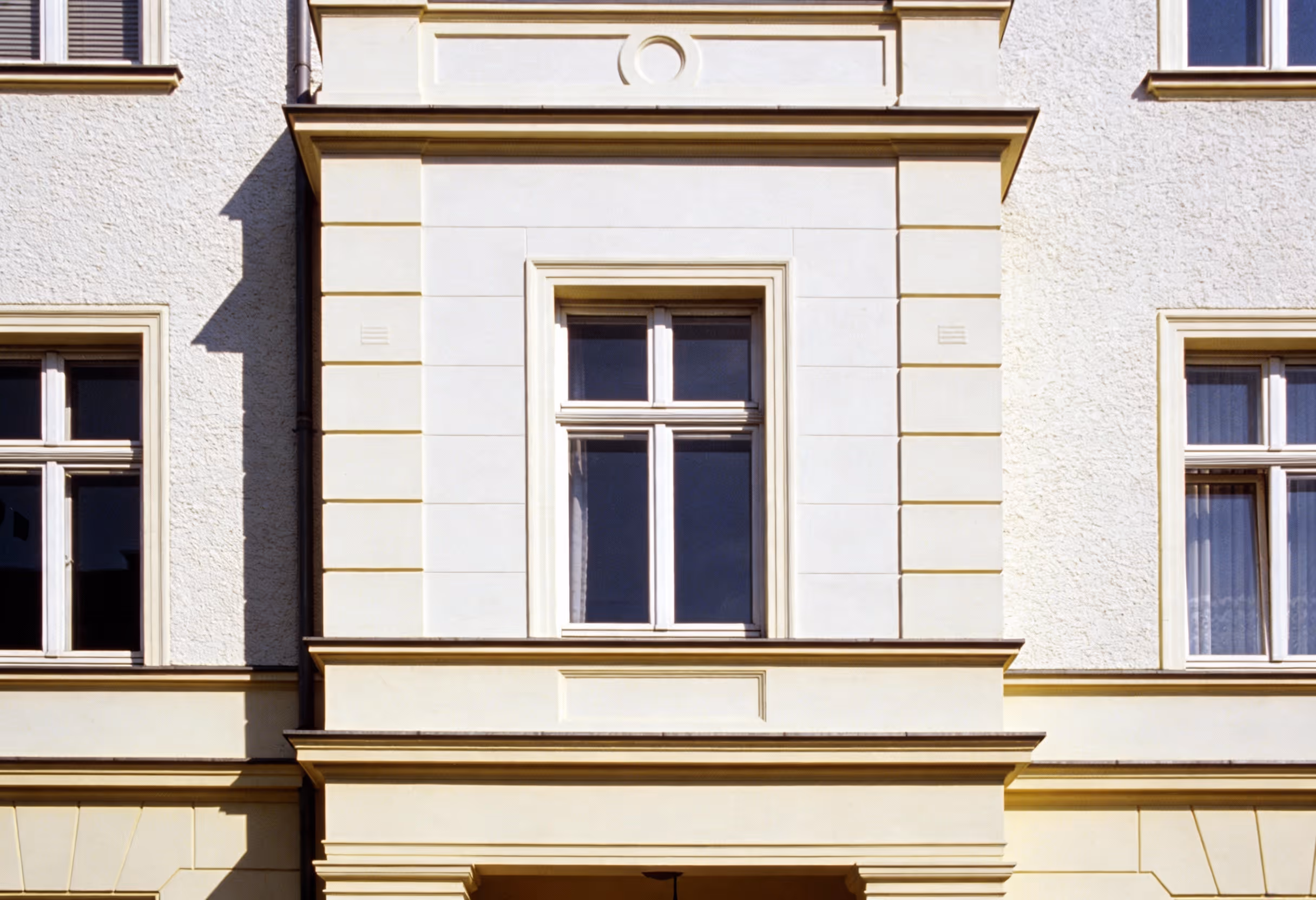 fassade eines geb udes mit drei wei en fenstern und einer hellgelben umrahmung